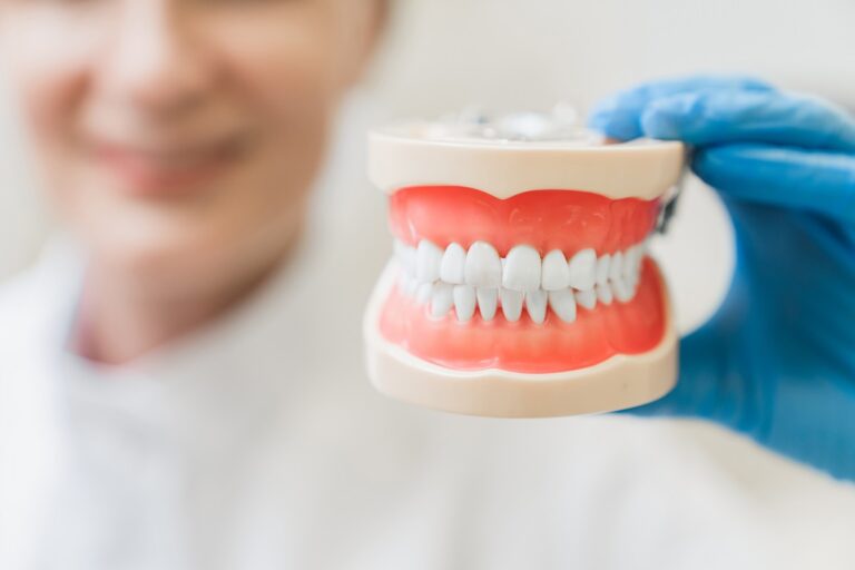 Dentista mostrando prótesis dental en consulta en Santa Coloma de Gramenet