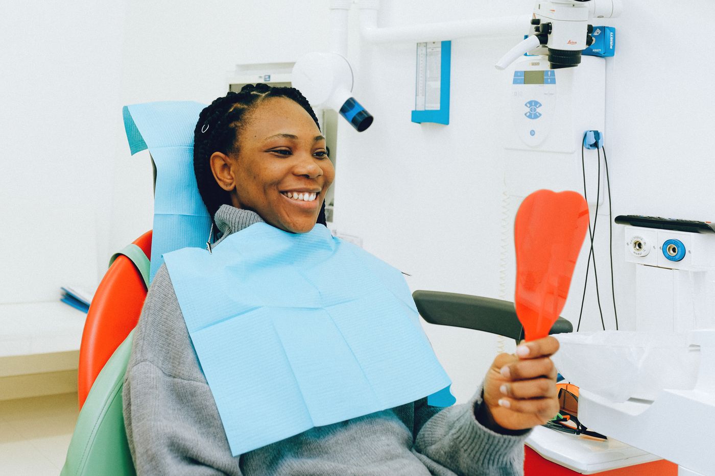 Mujer mirándose los dientes y las encías en un espejo