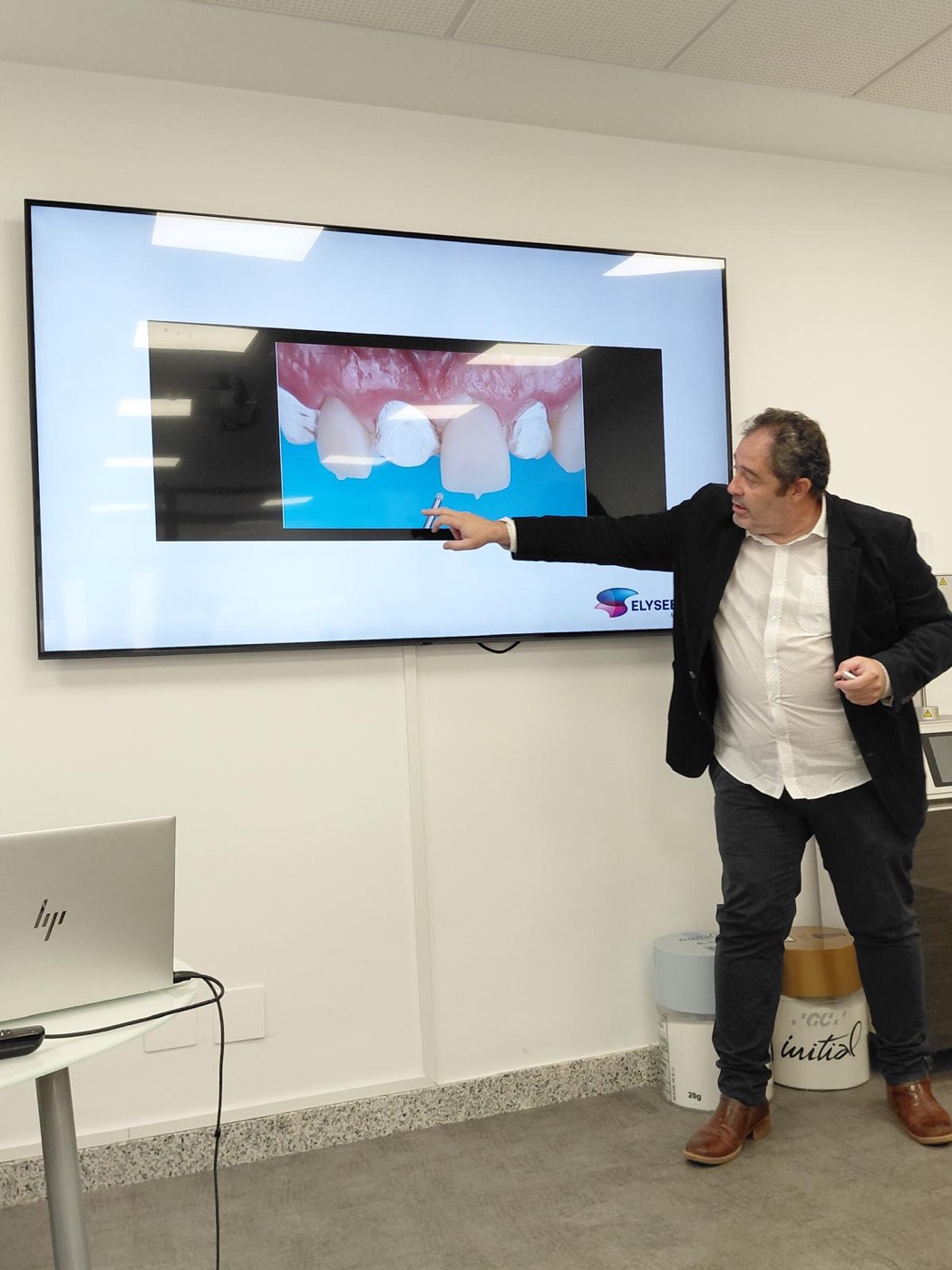 Ponente explicando en pantalla un caso de dientes anteriores con composite inyectado