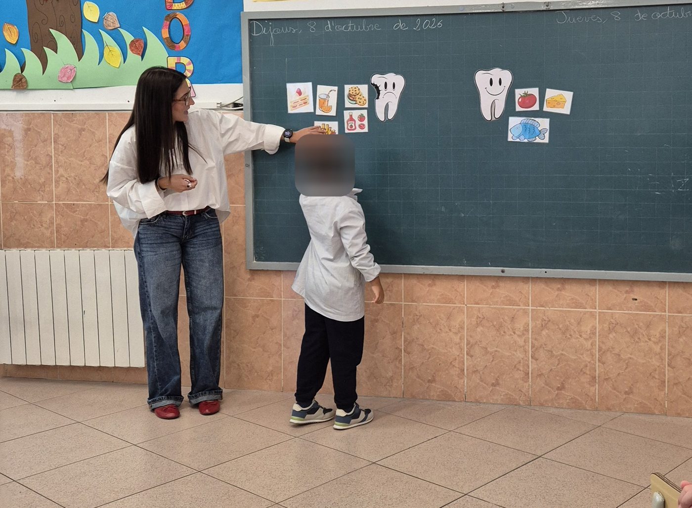 Profesional explicando en la pizarra alimentos y un diente dibujados durante la charla