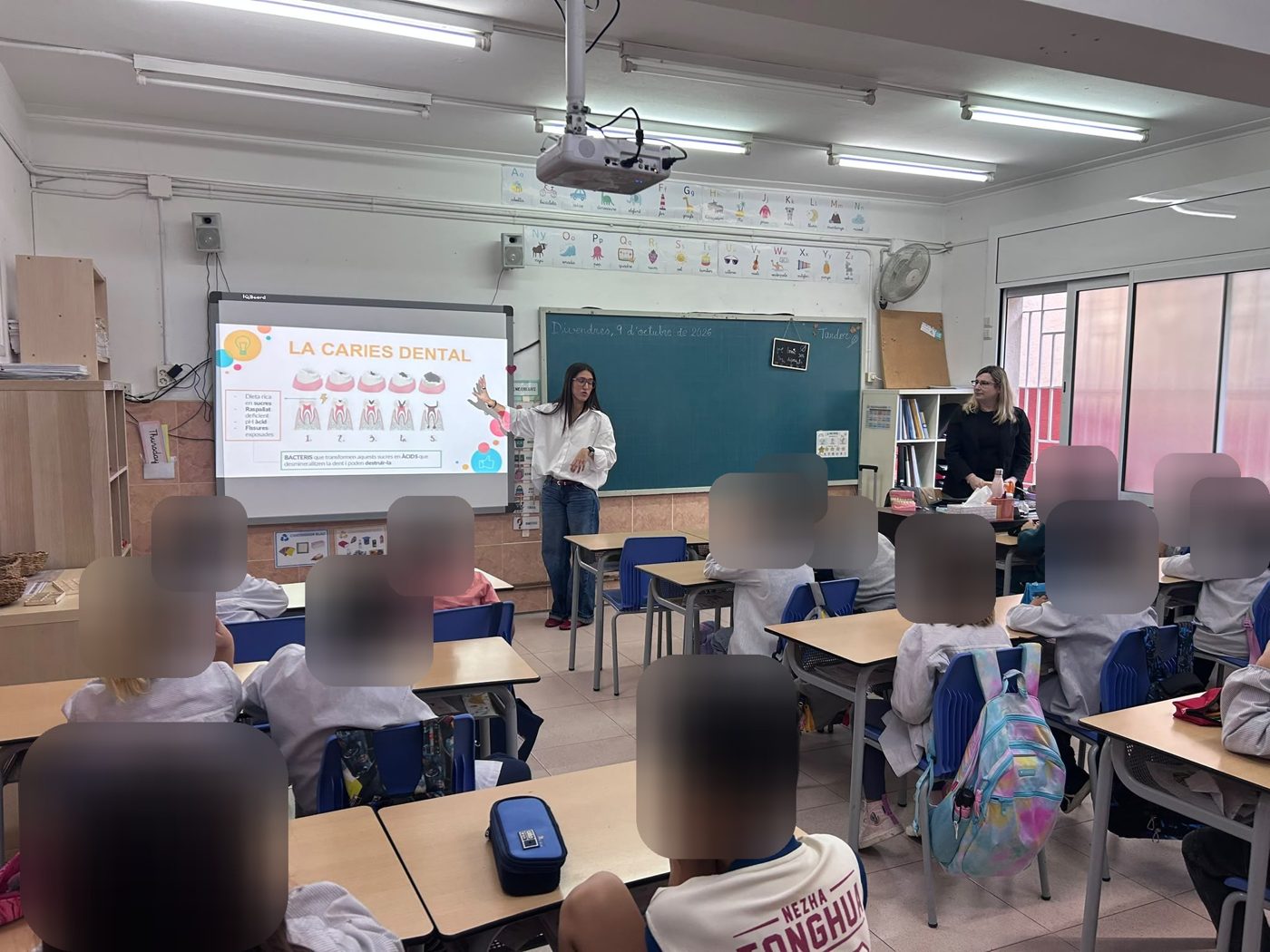 Alumnos levantando la mano para participar en la charla de la Escuela Manent