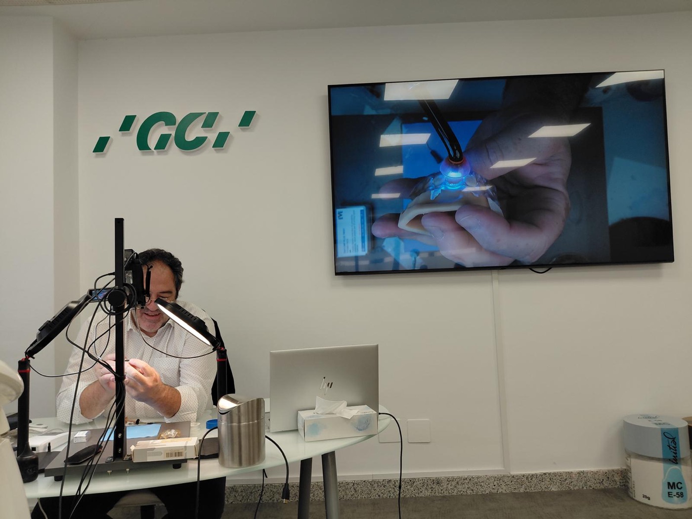 Ponente realizando una demostración en directo de composite inyectado con el logo de GC
