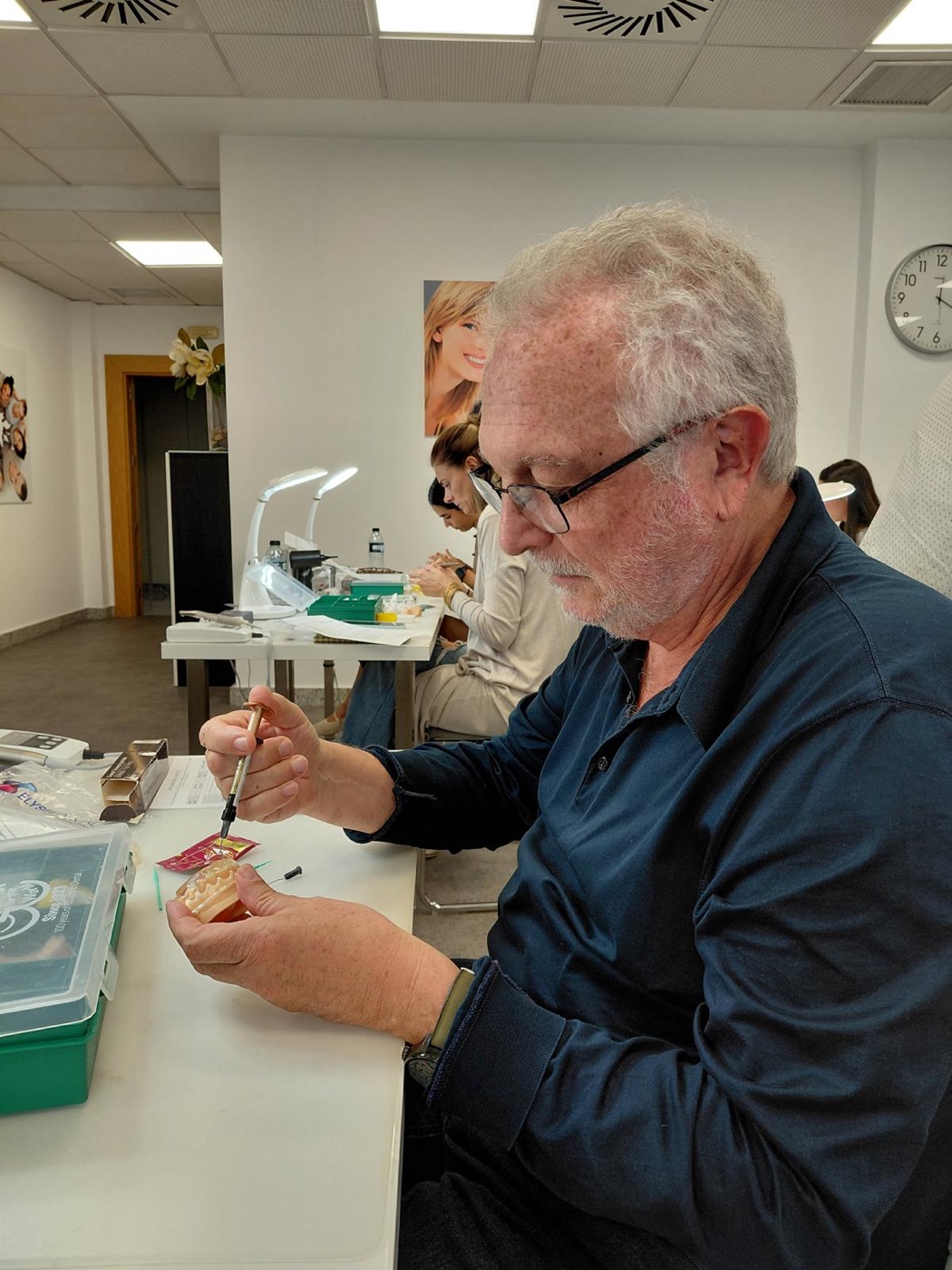 Dr. Mas practicando composite inyectado con una jeringa sobre un modelo dental en el aula del curso