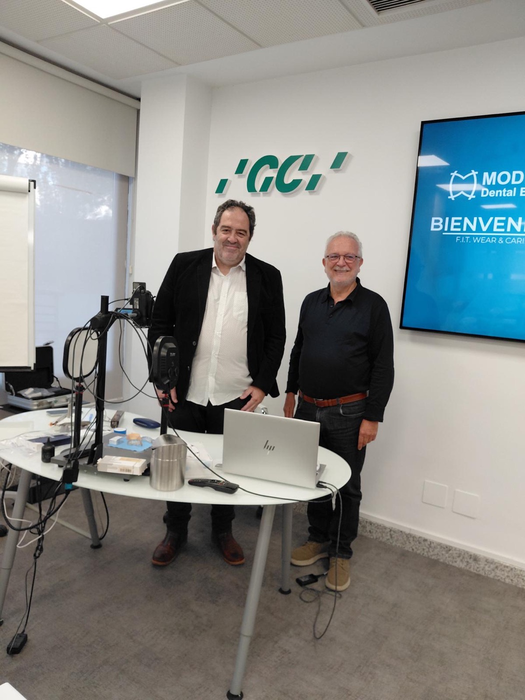Dr. Mas junto al ponente del curso con el logotipo de GC al fondo